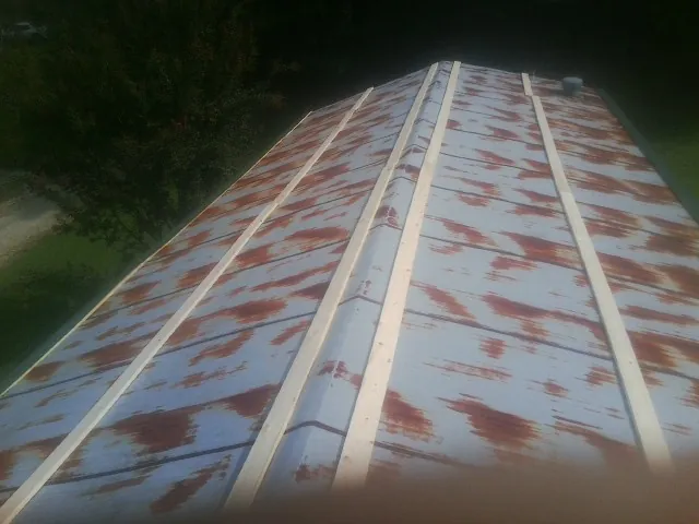 Rusted metal roof panels with new wood purlins before replacement — Storm Damage Roof Repair in Nickerson by Roofing Brothers