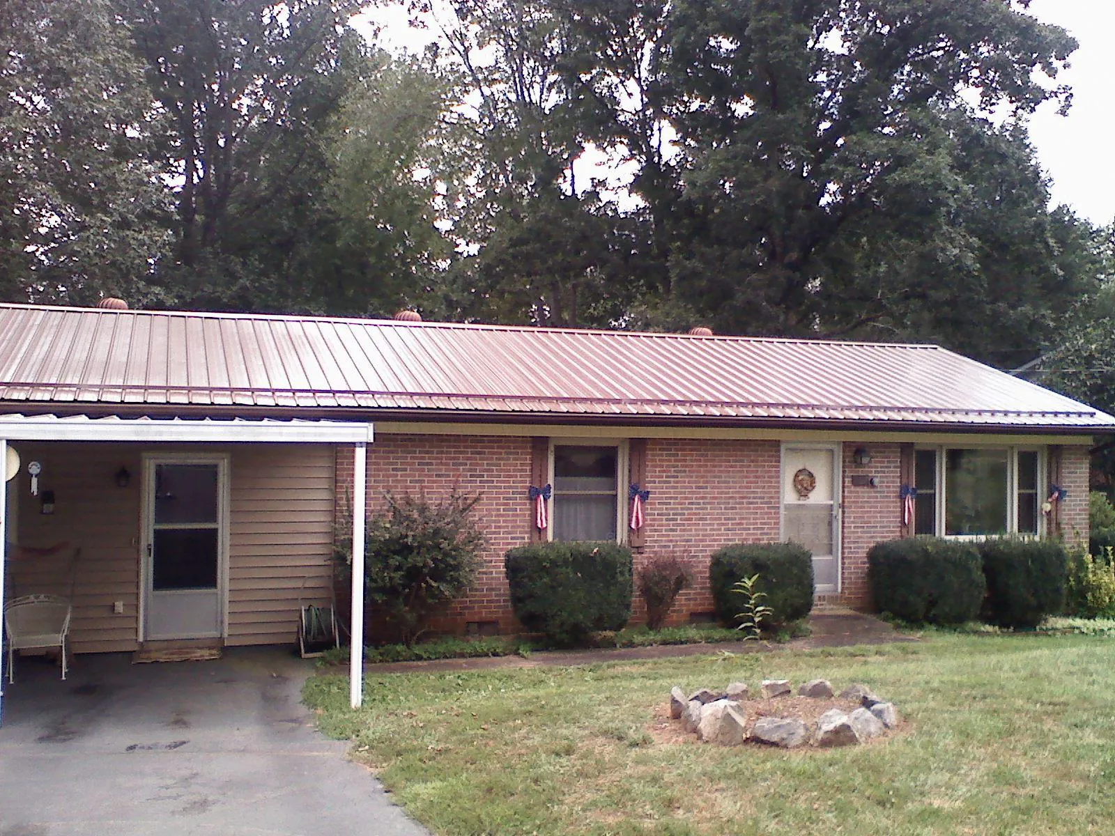 Bronze metal roof and carport on a brick ranch home — Roof Repair work by our crew in Nickerson