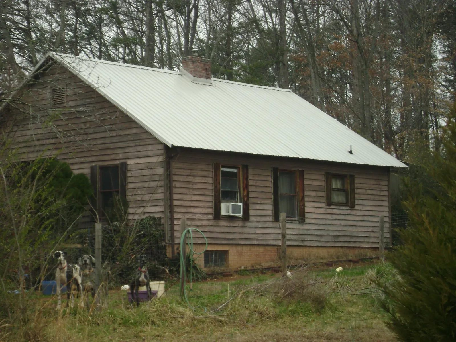 White metal roof on an old wood sided farmhouse, from a Metal Roof Installation job in Nickerson